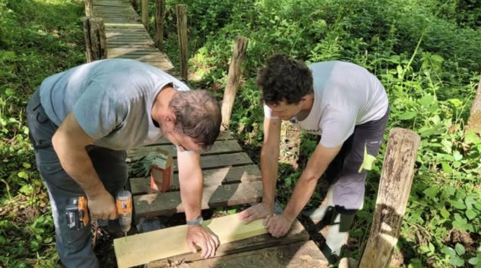 Bénévoles réparant les planches de la passerelle du Moulin Cognot